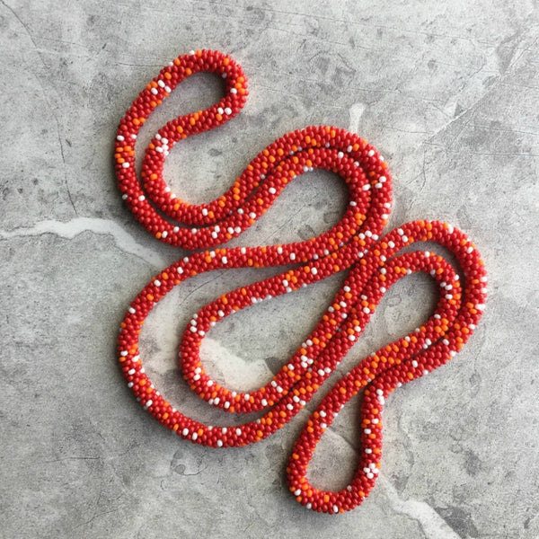 long continuous beaded crochet rope necklace in red, orange and white
