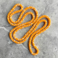 long continuous beaded crochet rope necklace in yellow-orange and cream